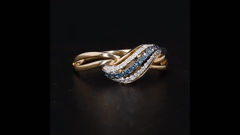 Indulge in the epitome of opulence with our 14K Yellow Gold Ring, a masterful creation that radiates luxury at every angle. At its heart lies an exquisite wave of blue diamonds, carefully curated to evoke the serene depths of the ocean. This centerpiece is embraced by a symphony of pristine white diamonds, elegantly adorning the duplicated band with their radiant sparkle. With a commanding width of 7.55mm at the pinnacle