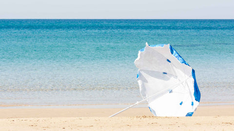 Runaway umbrella or blown away umbrella tumbling down the beach creating a stressful situation and potential for injury