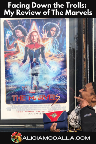 Alicia McCalla pointing to the Marvels Movie Poster encouraging people to go see the film.
