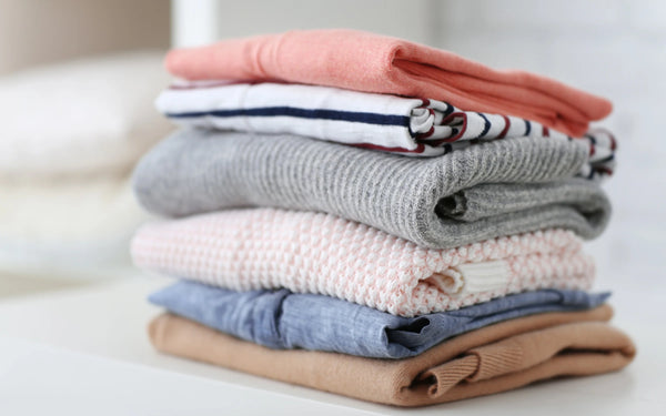 Piles de vêtements oversize sur table