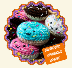 The image has a variety of sprinkle donut plushies.  There is white text on an orange background that reads "Mystery Sprinkle Donut"