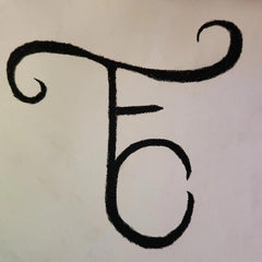 An insignia of T, F, and C (the letters combined overlayed) is drawn in black on a light tan piece of paper.