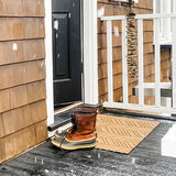 Durable All-Weather WaterHog Luxe outdoor doormat placed at the backdoor during snow and rainy weather.