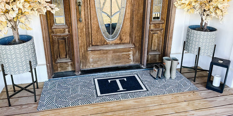 Large personalized double door doormat placed in front of larger door with sidelights.