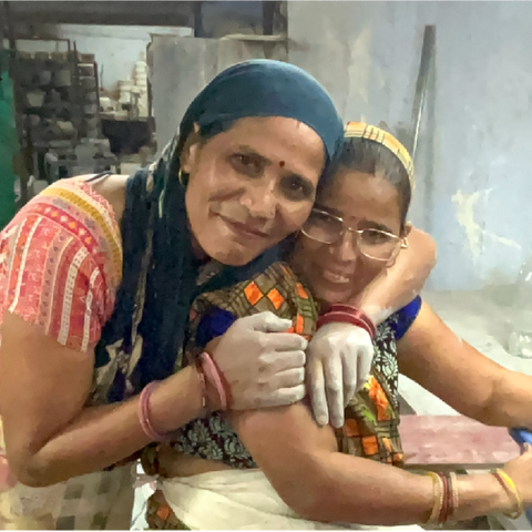 two women artisans of India hugging each other