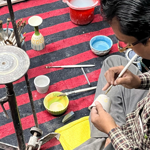 ceramic artisan of India painting on a ceramic glass