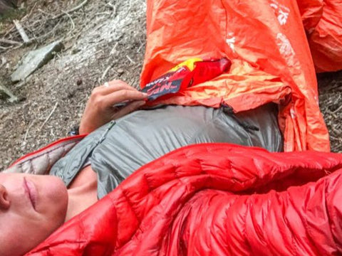 Woman in Escape Bivvy laying on ground