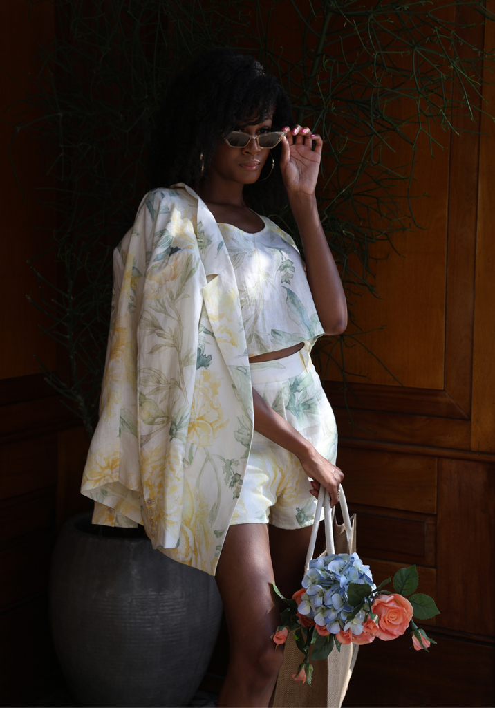 African American woman modeling a cream floral linen blazer and shorts set.