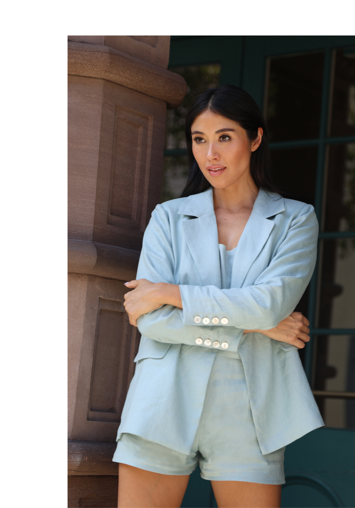 Asian looking woman modeling a blue linen blazer and shorts set.