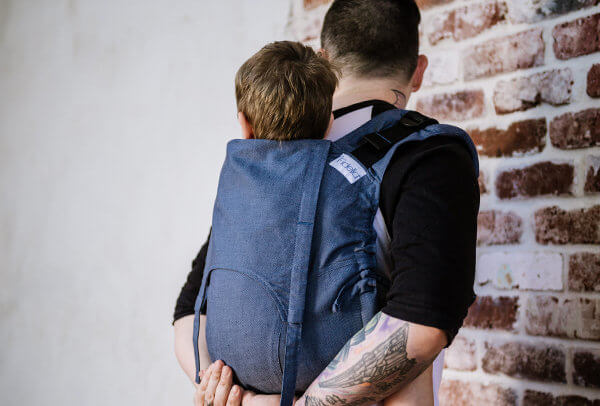 Infant in the Onbuhimo back carrier is carried by the father