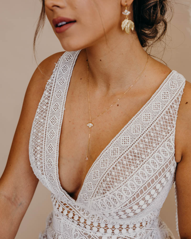 close up of a bride wearing a rose quartz y necklace