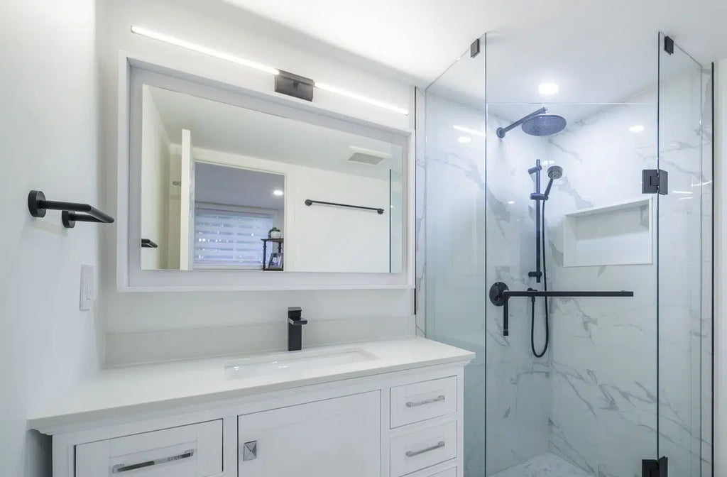 A sleek and modern bathroom with a minimalist aesthetic, featuring a glass shower enclosure, contemporary vanity, white dresser, and large window with blinds.