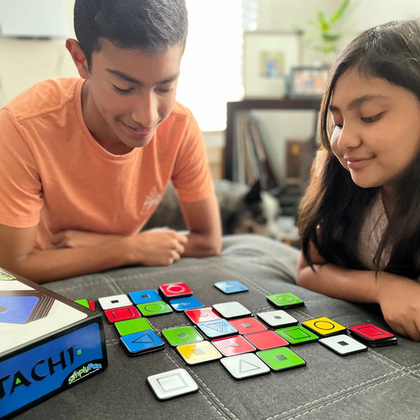 Two older kids playing Katachi by SimplyFun, a matching game focusing on spatial reasoning and planning for ages 8 and up.