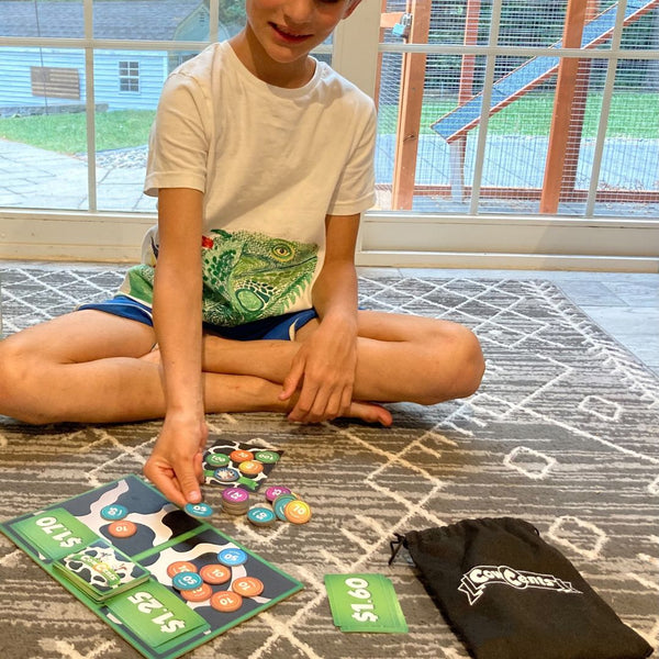 Boy learning to count money with math card game, Cow Centrs.