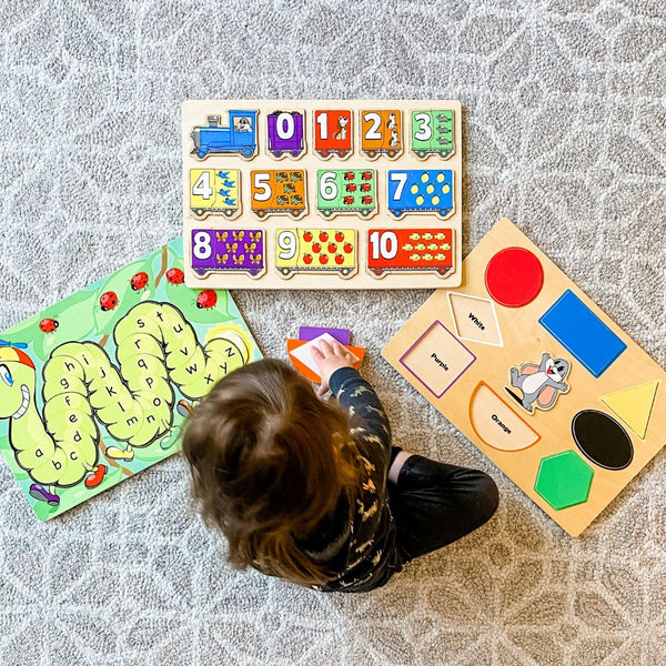 Preschooler playing three wooden puzzle games. Number Recognition Activities for Preschoolers