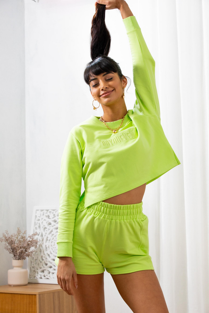 Model poses holding her ponytail up in the air, eyes shut wearing doyoueven activewear