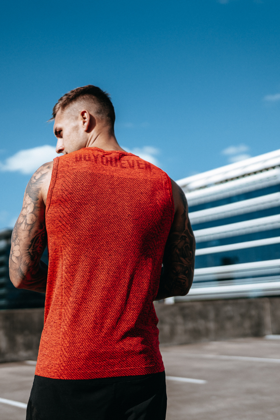 Male Fitness models poses with his back outside wearing Doyoueven mens focus seamless