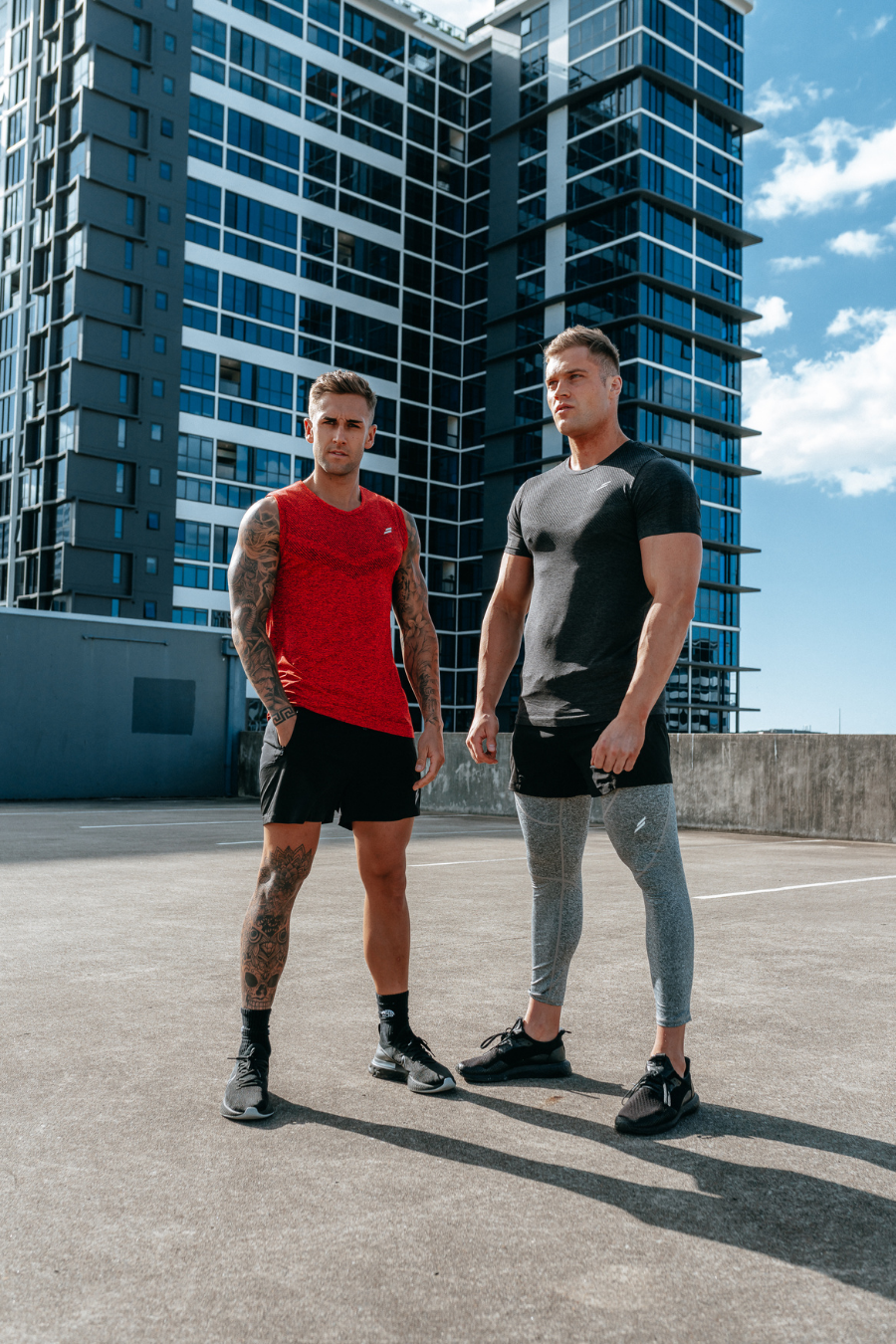 Two male fitness models pose on a city rooftop wearing Doyoueven mens seamless