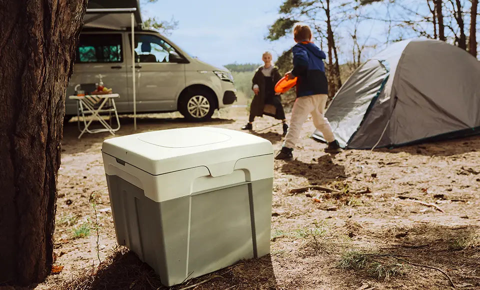 Camper toilet in front of tent and van