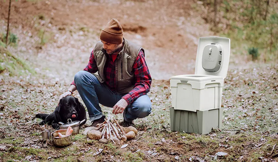 Off-grid toilet next to man with dog
