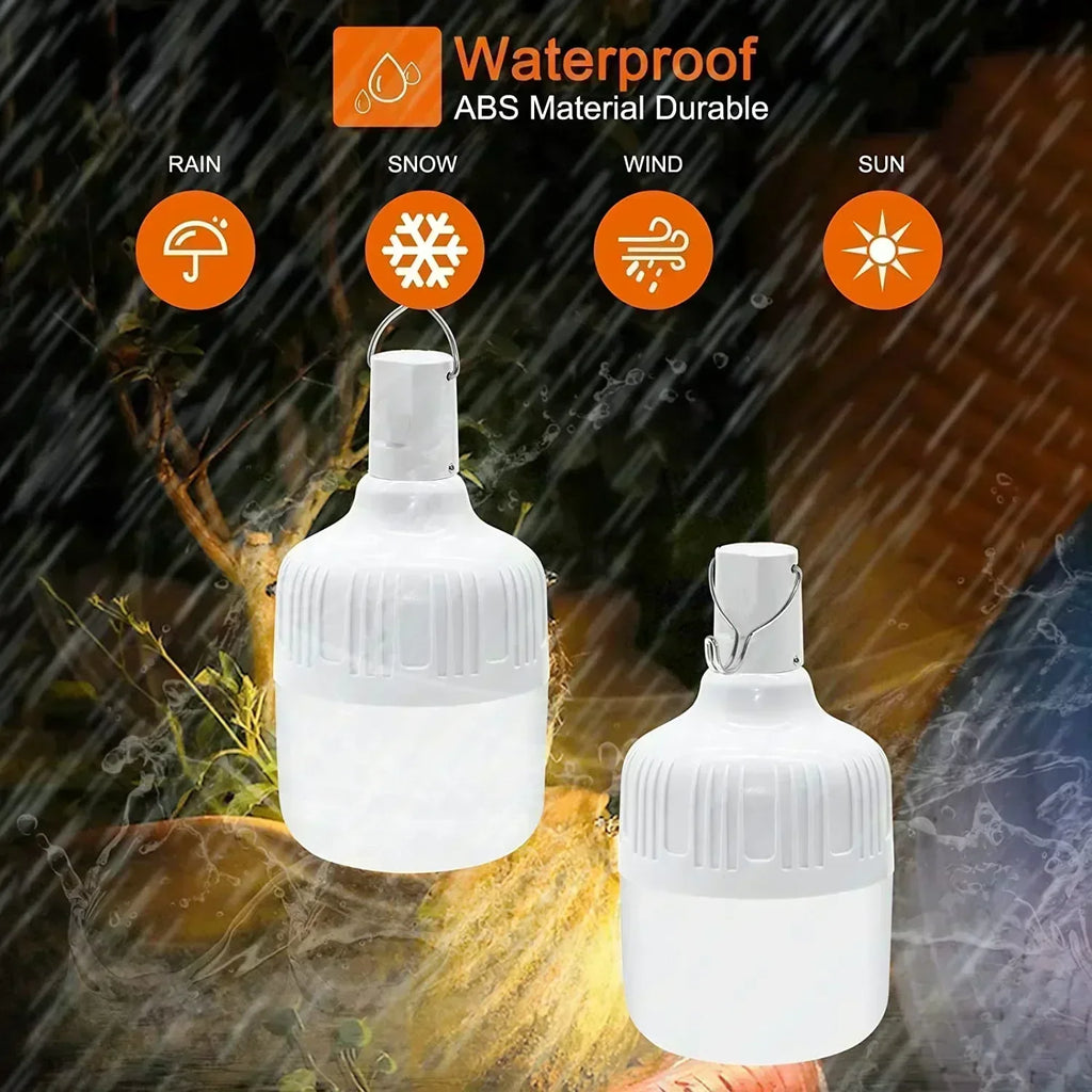 Two white, waterproof USB Rechargeable LED Light Bulb Lanterns from The Stuff Box hang outdoors in heavy rain. Icons illustrate their durability against rain, snow, wind, and sun. Text indicates the lanterns are made of durable ABS material and feature adjustable brightness with a rechargeable battery for ultimate convenience.