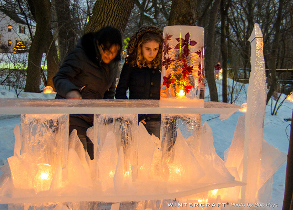 Young woman looking at Leaf Flower Tower on ice bar at the 2018 Middlemoon Creekwalk Wintercraft Ice Wrangler