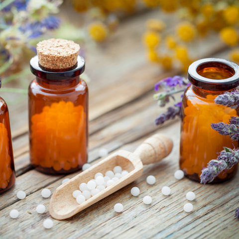 homeopathy globules in jars and in a scooper with lavender sprigs 