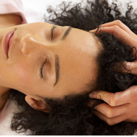 hands are placed on the head of an individual lying on their back