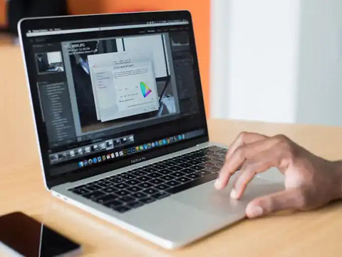 Ma using a MacBook Pro in his office in Miami. He's enjoying his just repaired trackpad, a service performed by Prime Tech Support technicians in Miami