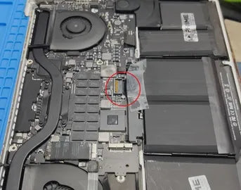 Internal view of a laptop showing components such as the fan, battery, and
          circuitry on a blue work mat. The battery connector is highlighted with a
          red circle. A battery label reads 'PRIME TECH SUPPORT' suggesting
          maintenance or parts from Prime Tech Support in Miami, Florida