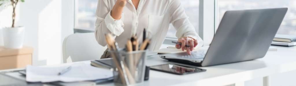 Mujer usando su computadora portátil en Miami mientras nuestro equipo ofrece un asistente de TI para resolver el rendimiento lento de su computadora portátil