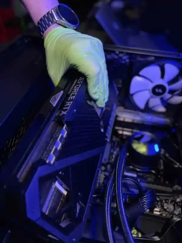 Un técnico de soporte técnico de Prime que demuestra el método correcto para sostener una GPU, con los dedos colocados de forma segura a lo largo de los bordes y evitando componentes sensibles en Miami, Florida.