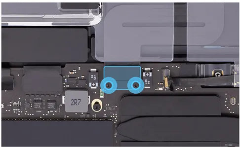 Close-up of a MacBook Pro's internal board featuring a blue-highlighted screw area, multiple electronic components, and a chip labeled '2R7'