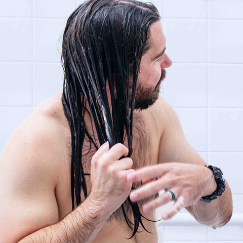 man with long hair shampooing