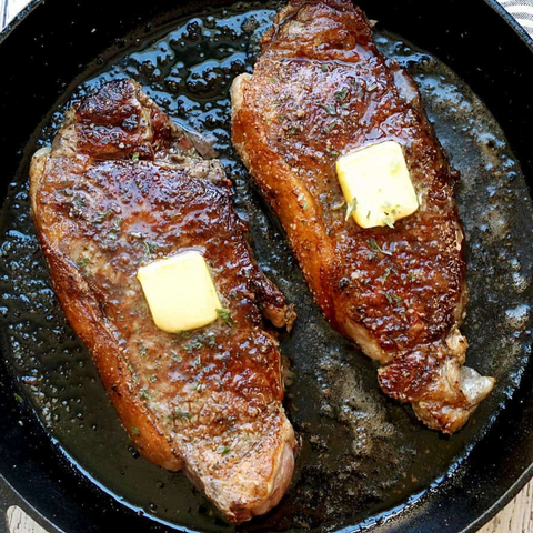 cooked new york strip steak with butter