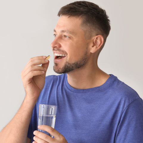 man hydrating and taking vitamin