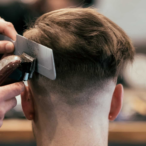 man getting fade with comb