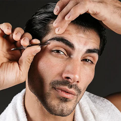 man plucking eyebrows with tweezers
