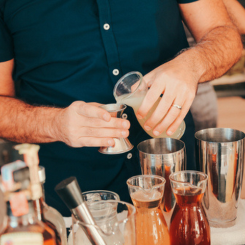 man mixxing cocktail in kitchen