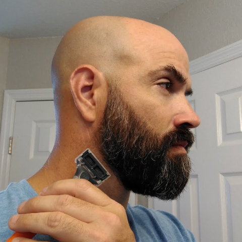 man trimming beard neckline with precesion