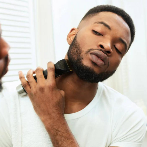 man carefully trimming neckline with clipper