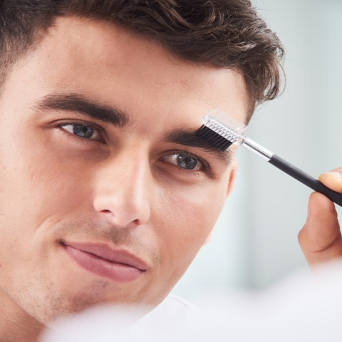 young man using spoolie on eyebrows