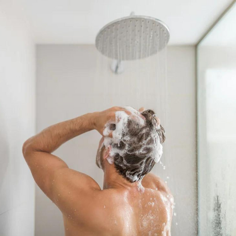 man shampooing hair in the shower