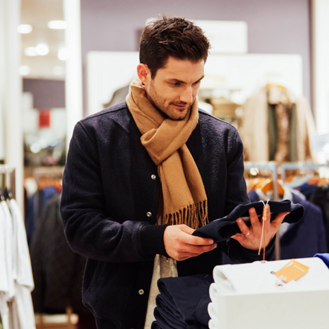 man checking shirt before purchase