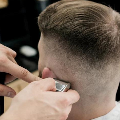 man getting skin fade around ear