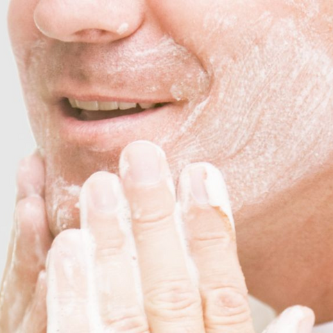 man scrubbing face with scrub