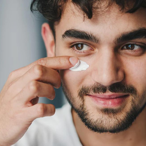 man applying eye cream