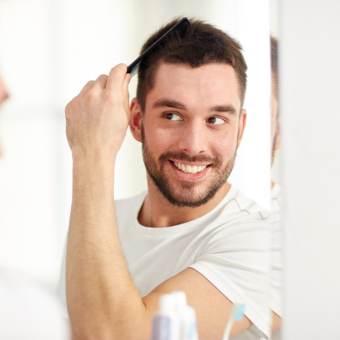 man styling hair with comb