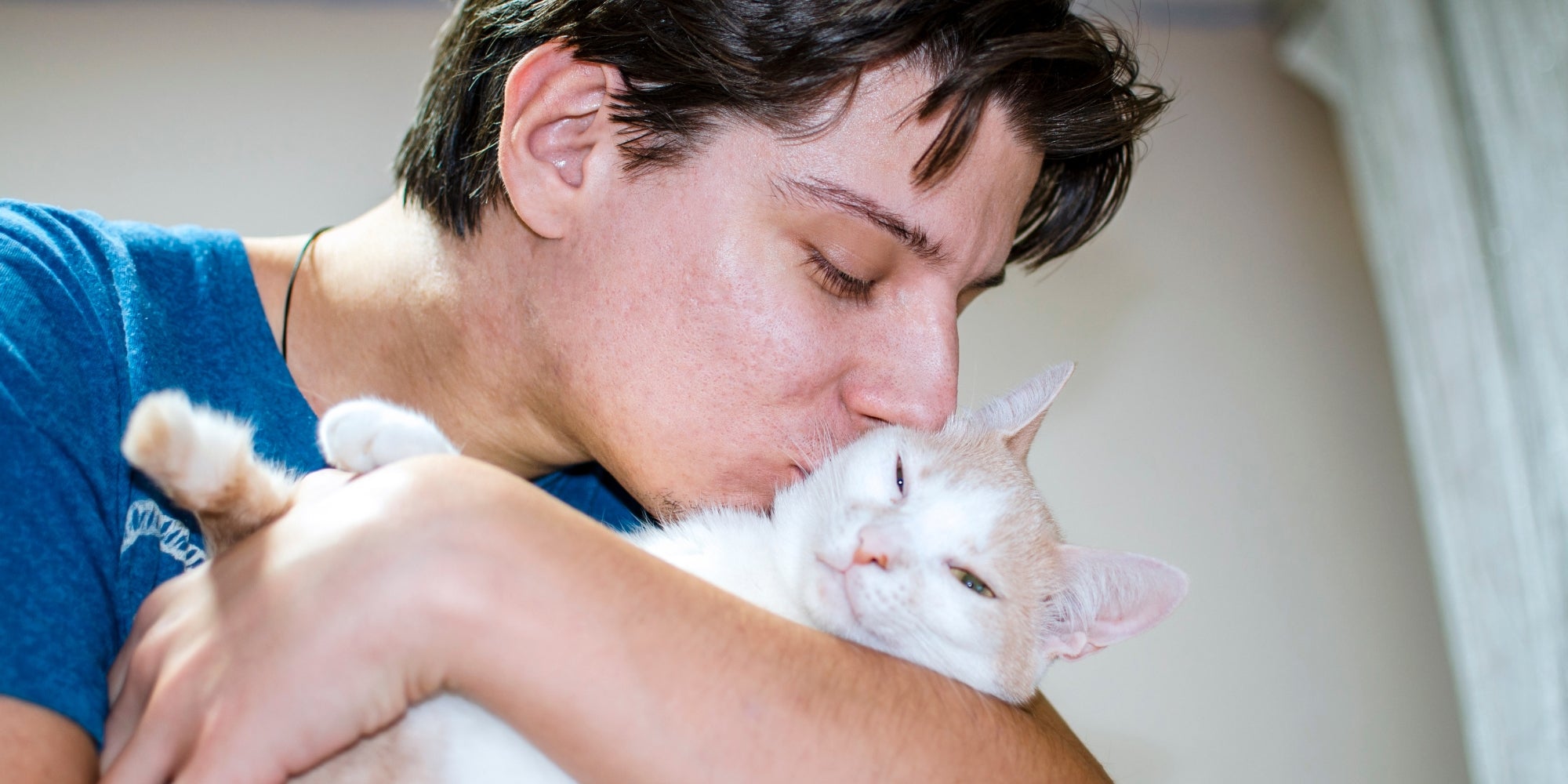 Hombre abrazando y besando a un gato