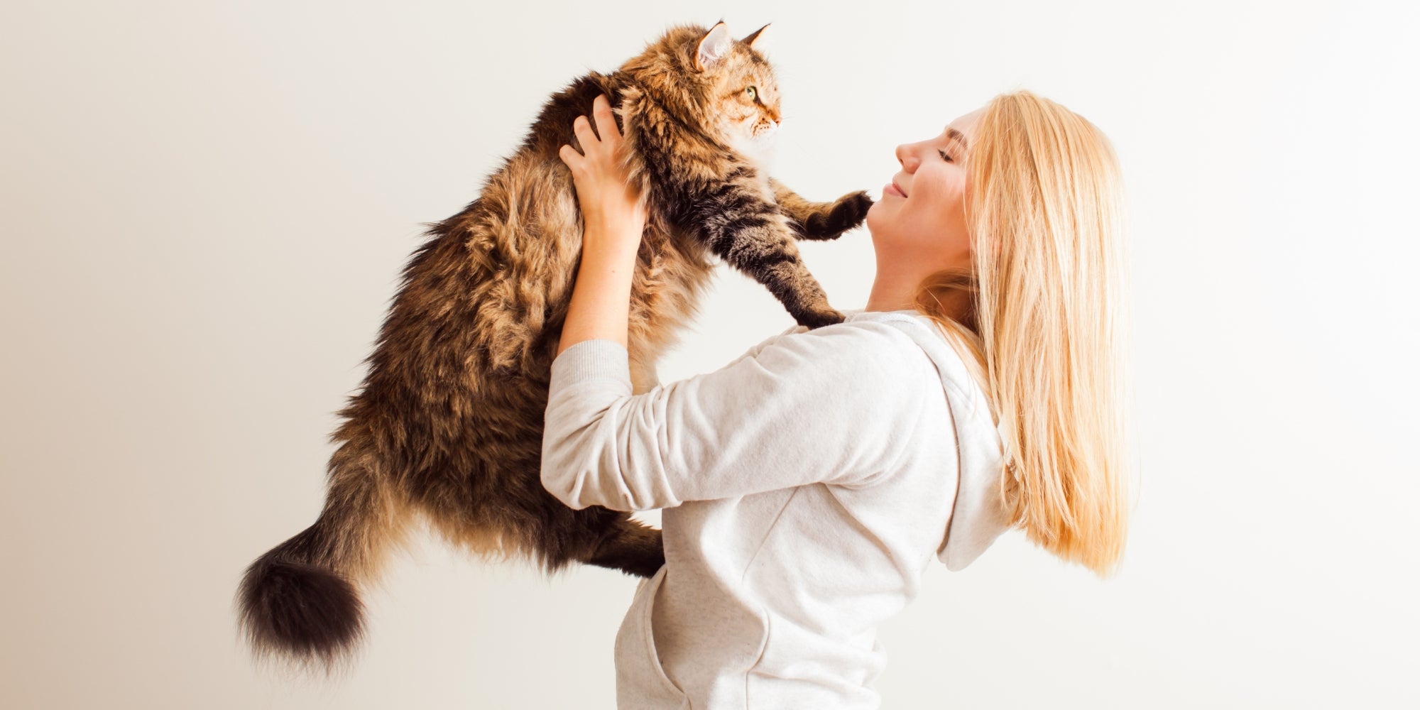 Mujer feliz jugando con su nuevo gato adoptado